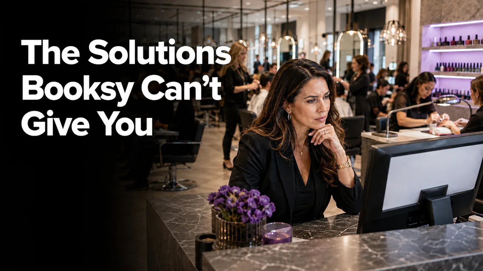 Salon owner studying a screen at the front desk of a busy salon, captioned: the solutions Booksy can't give you